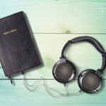 Headphones with Bible in a wooden table.